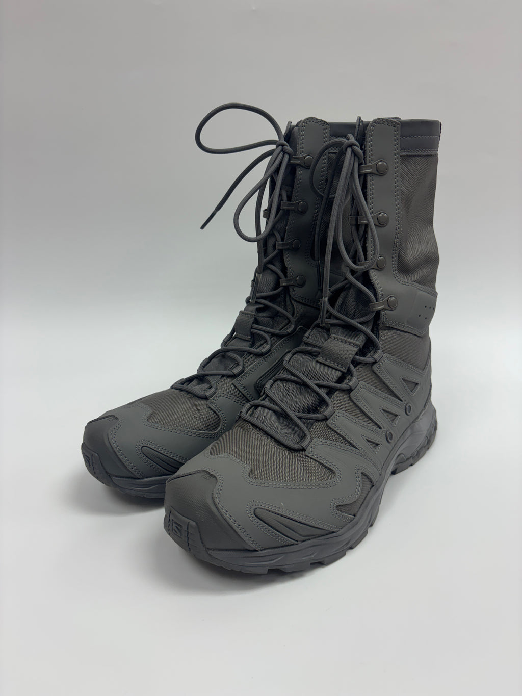 A pair of dark gray tactical combat boots with matching laces, shown on a light gray studio background.