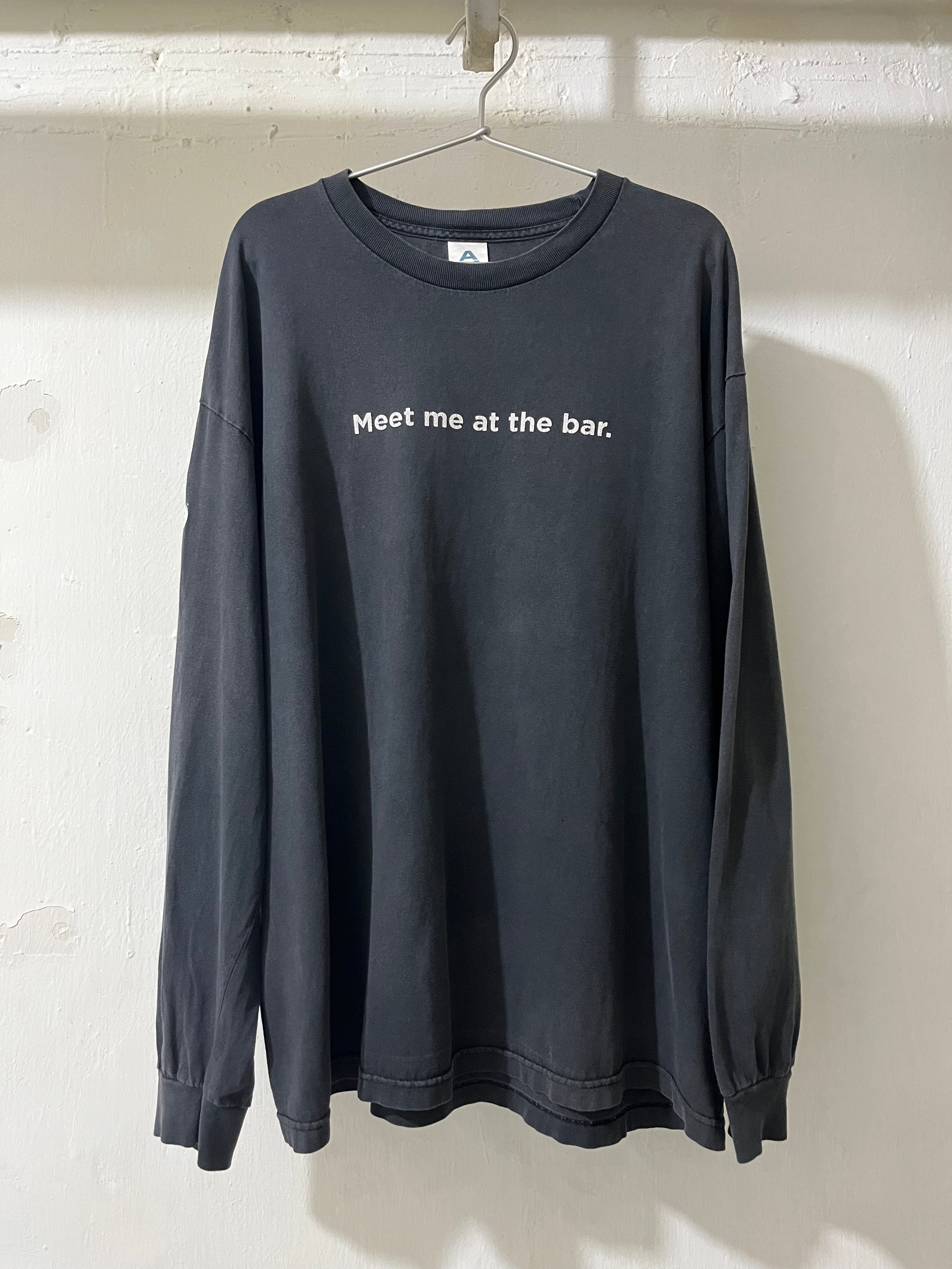 Black long-sleeve shirt with 'Meet me at the bar.' text on a white background